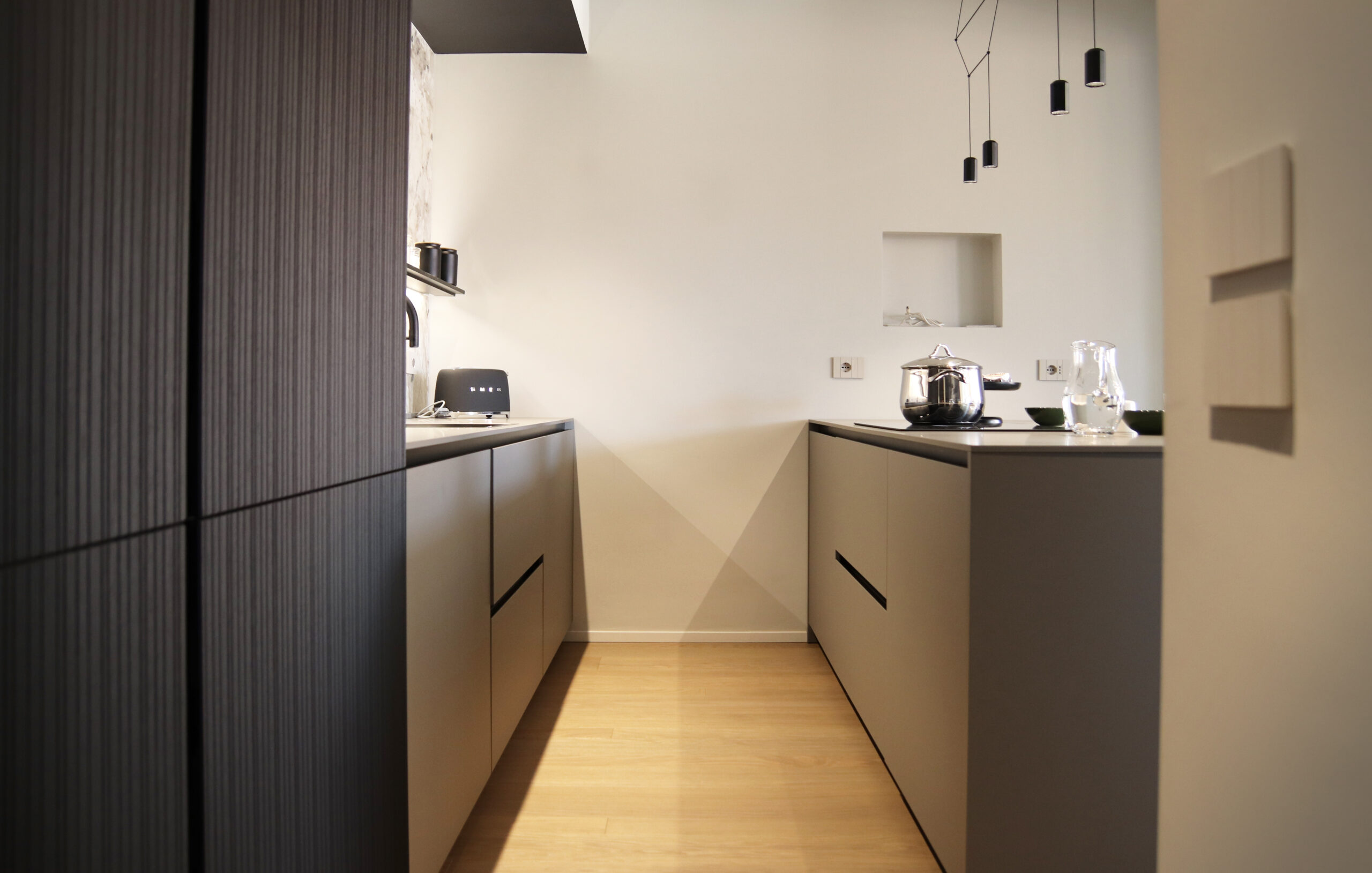 Cucina modello Nautila di Arrital. Colonne anta plancia fresata assimetrica in rovere black. Basi laminato Fenix Grigio Londra. Top in laminato Fenix grigio Londra. Elettrodomestici Miele. Piamo induzione con sistema di aspirazione Bora. Progetto Arch. Caterina Pegazzano